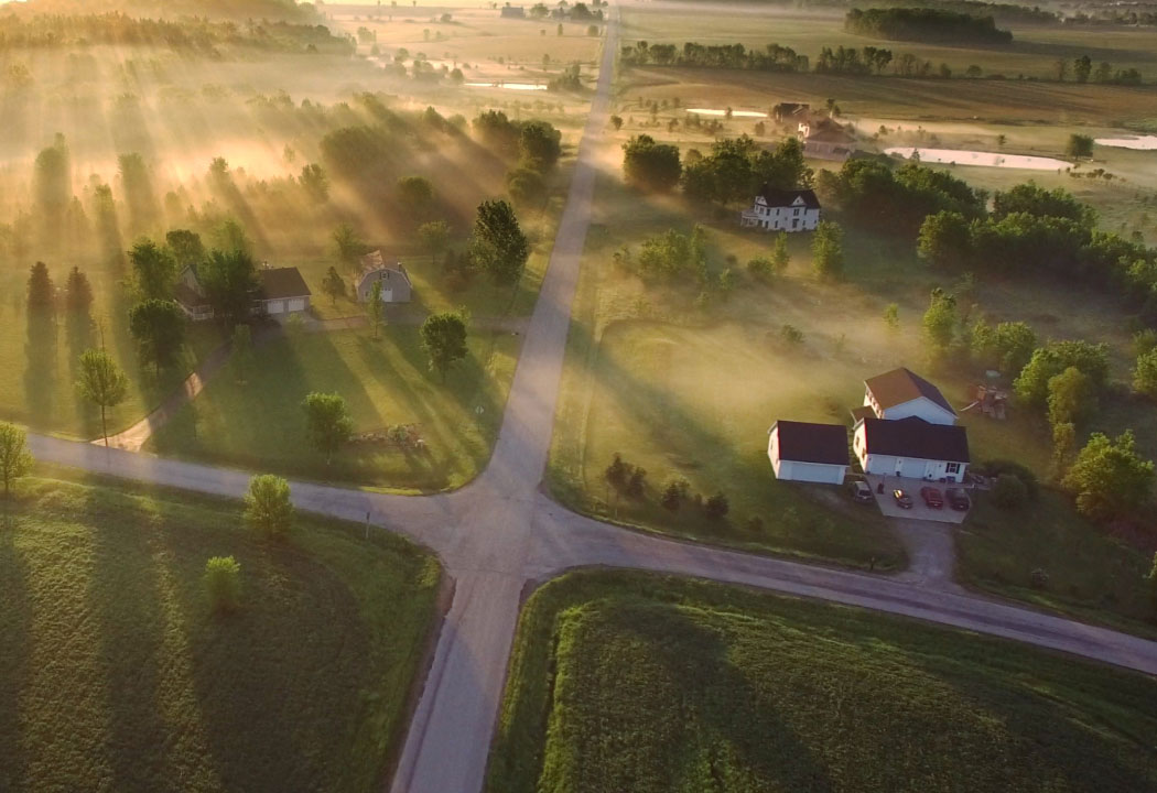 drone shot of large homes on a rural road